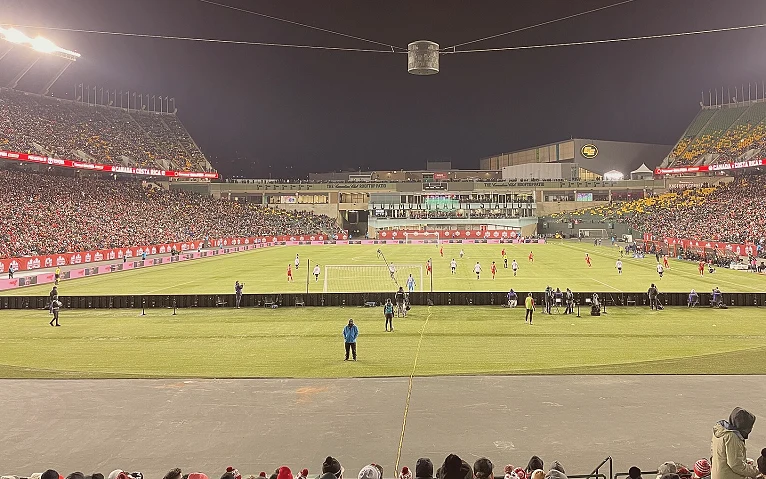 赛季末积分榜前的球门与场地全景（场次错位与赛程不对称）